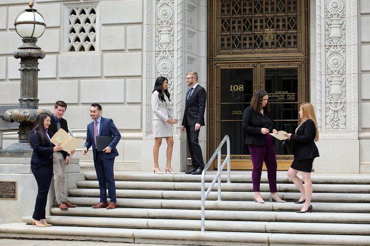 Law students stand on the steps of the Capitol building.